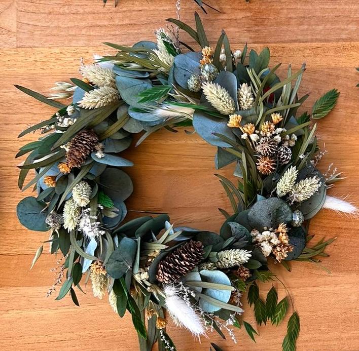 Corona de Navidad de flores preservadas en tonalidades naturales y blancas.