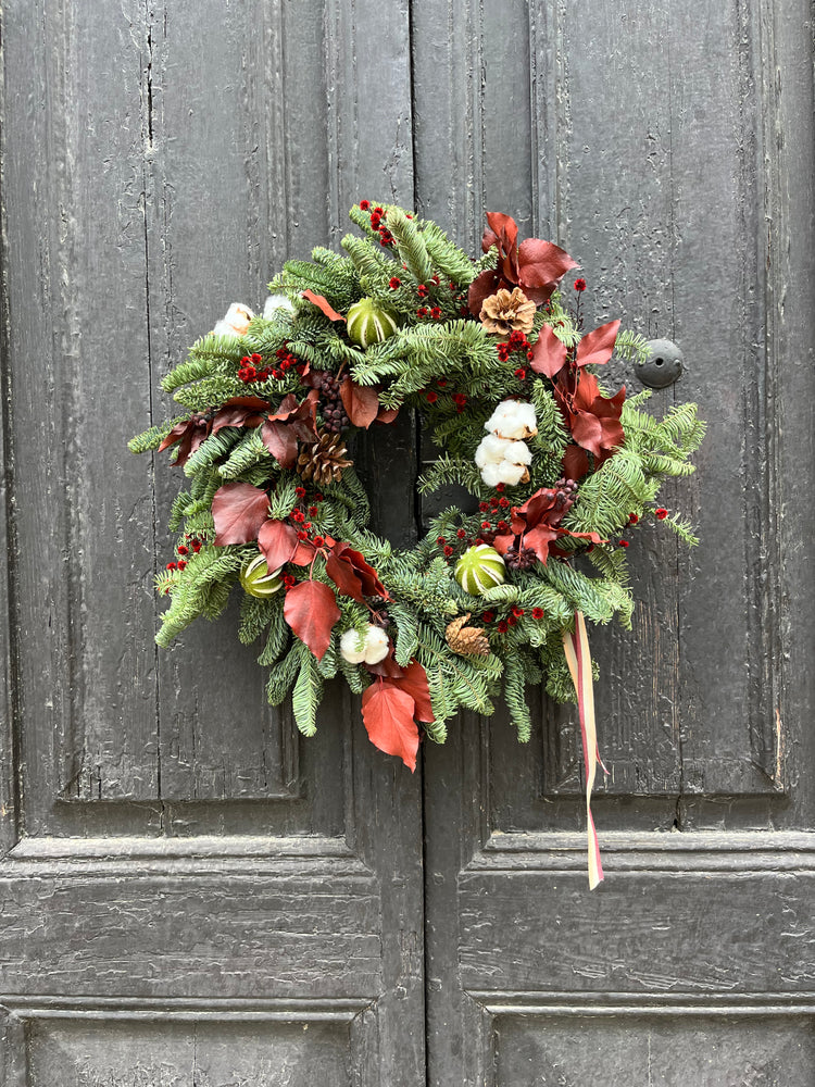 Corona de Navidad natural con detalles en tonos burdeos