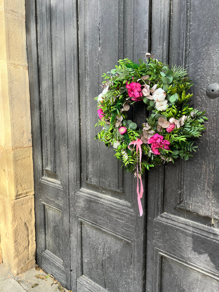 Corona de Navidad preservada decorada con flores en tonalidades rosada
